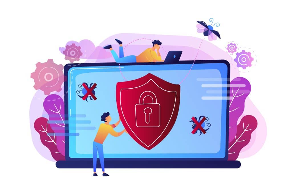 Des personnes travaillent sur un ordinateur portable avec un bouclier affiché à l'écran, symbolisant la cybersécurité.